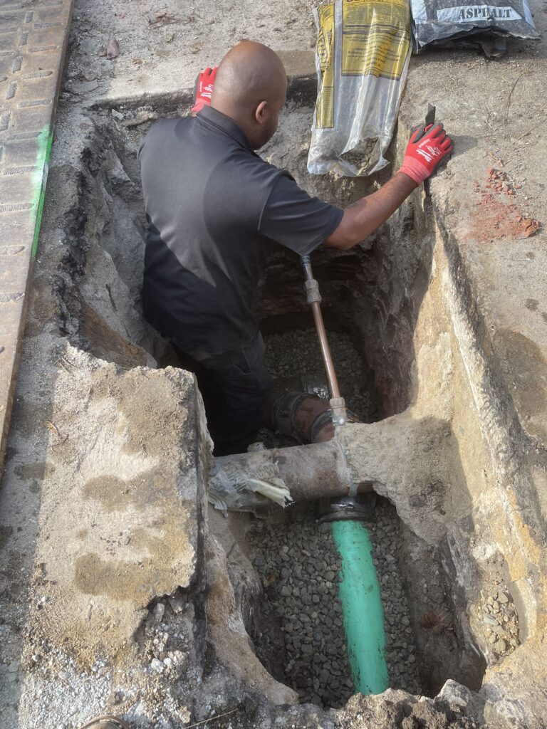 Lords of Plumbing technician working on an underground line in an excavated trench