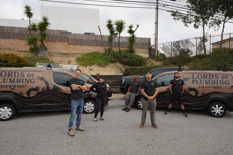The Lords of Plumbing crew standing with company service vans
