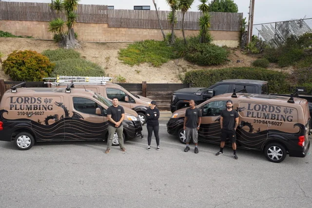 Lords of Plumbing team standing with company vans