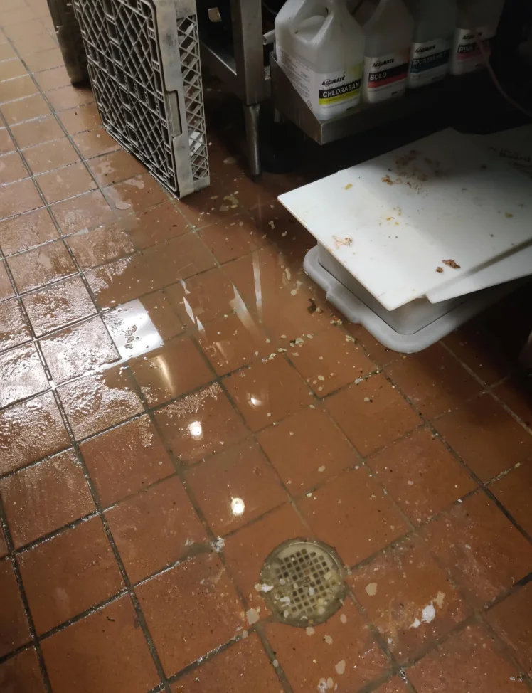 Water pooled on a tile floor from a plumbing leak