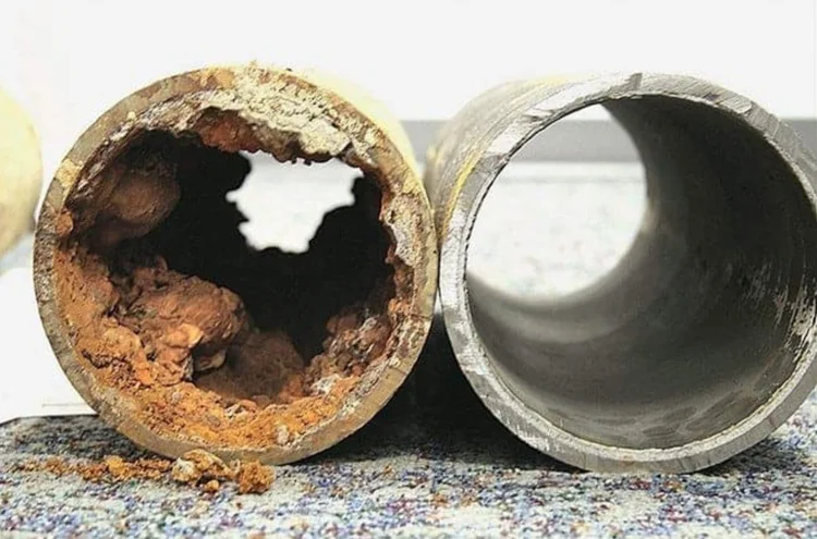 Cross-section of a corroded old pipe next to a new replacement pipe